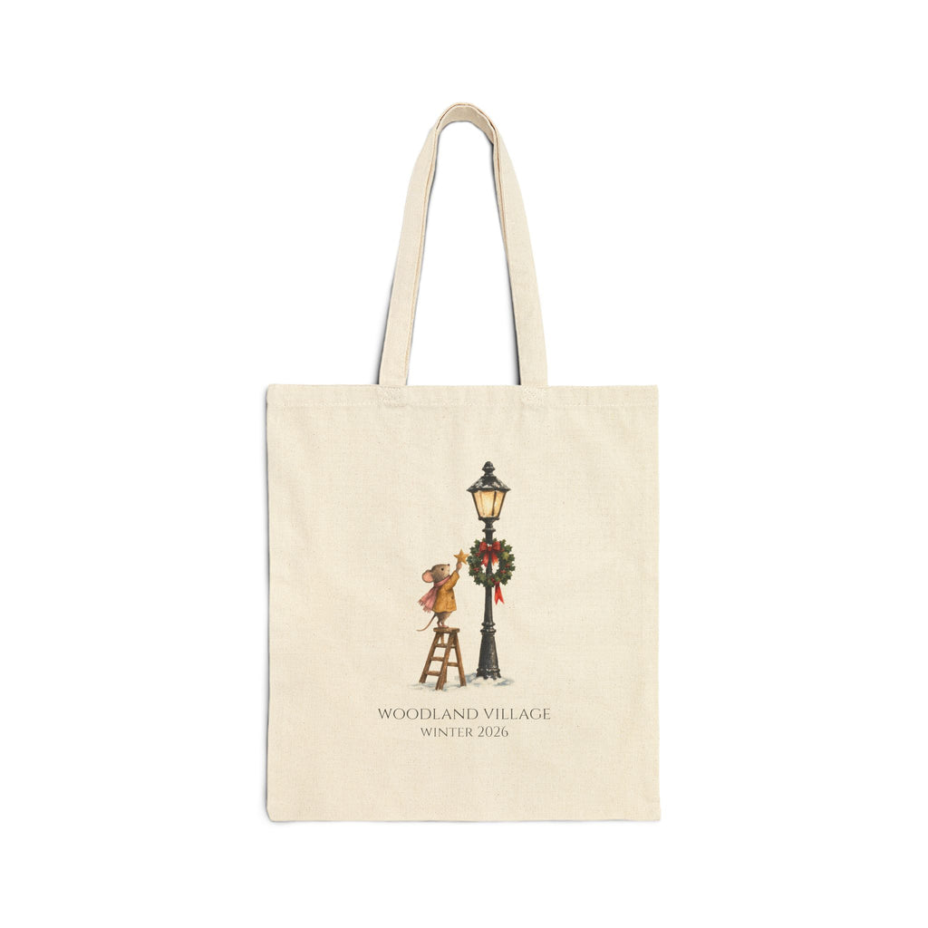 Natural canvas tote with a mouse on a ladder hanging a star by a wreathed lamppost